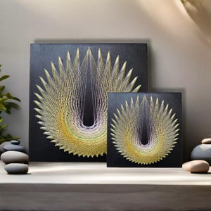 May include: Two black framed string art pieces with a geometric design in shades of yellow, green, and purple. The larger piece is on the left and the smaller piece is on the right.
