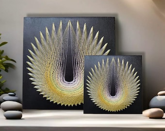 May include: Two black framed string art pieces with a geometric design in shades of yellow, green, and purple. The larger piece is on the left and the smaller piece is on the right.