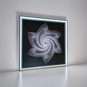 May include: A framed black and white geometric art print featuring a white spiral design on a black background.