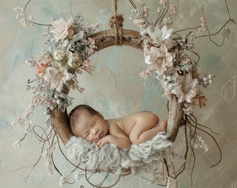 May include: A newborn baby sleeping peacefully in a rustic wooden wreath decorated with delicate white and pink flowers. The wreath is hanging from a white ceiling.