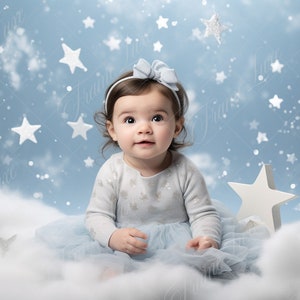 May include: A baby girl wearing a light blue tulle dress and a white sweater with silver stars sits on a fluffy white cloud. The background is a light blue with white stars.