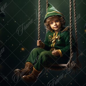 Puede incluir: Un niño pequeño vestido de elfo se sienta en un columpio de cuerda sobre un fondo verde oscuro con luces brillantes. El elfo lleva un traje verde y dorado con un gorro puntiagudo y botas marrones.