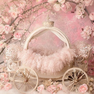 May include: A white carriage with a pink fluffy interior and a crown on top. The carriage is surrounded by pink flowers and a pink background.