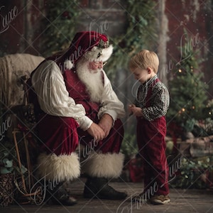 May include: A festive image of Santa Claus, dressed in a red suit and hat, conversing with a young child. The child is wearing a plaid shirt and red dungarees. The backdrop is a Christmas scene with greenery and soft lighting.