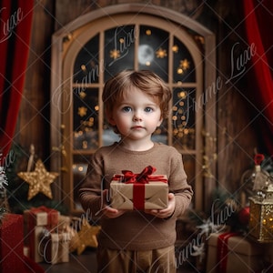 May include: A young child dressed in a brown sweater holds a wrapped gift box with a red ribbon in front of a rustic wooden window with a red curtain on either side. The window has a view of a moon and stars.
