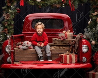 Könnte beinhalten: Ein kleiner Junge in einem roten Pullover sitzt auf der Ladefläche eines roten, vintage Pick-up Trucks, der für Weihnachten geschmückt ist. Der Truck ist von Weihnachtsbäumen und Geschenken umgeben.