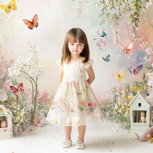 May include: A young girl wearing a white dress with floral print stands in front of a whimsical backdrop featuring birdhouses, blooming flowers, and butterflies.