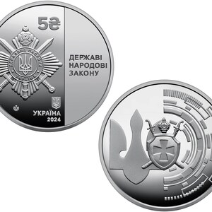 May include: A silver coin with a value of 5 hryvnias. The obverse side features the emblem of the State Guard of Ukraine with the inscription "Держави народoви закону" (State Guard of Ukraine). The reverse side features a stylized image of the trident, the national symbol of Ukraine, with a cross and swords. The inscription "Україна 2024" (Ukraine 2024) is also present.
