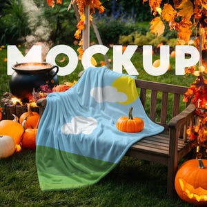May include: A blue fleece throw blanket with a white cloud and yellow sun design. The blanket is draped over a wooden bench with pumpkins in the foreground. The text "MOCKUP" is visible in the background.