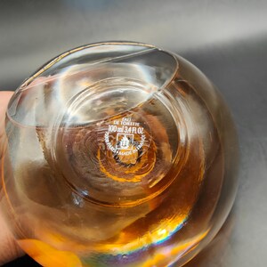 Puede incluir: Una botella de vidrio transparente con un l&iacute;quido dorado en su interior. La botella tiene una etiqueta que dice "Eau de Toilette 100 ml 3.4 fl oz" y "Made in France".