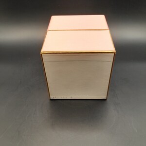 May include: A pink box with a gold trim and the text "MADE IN FRANCE" on the bottom.