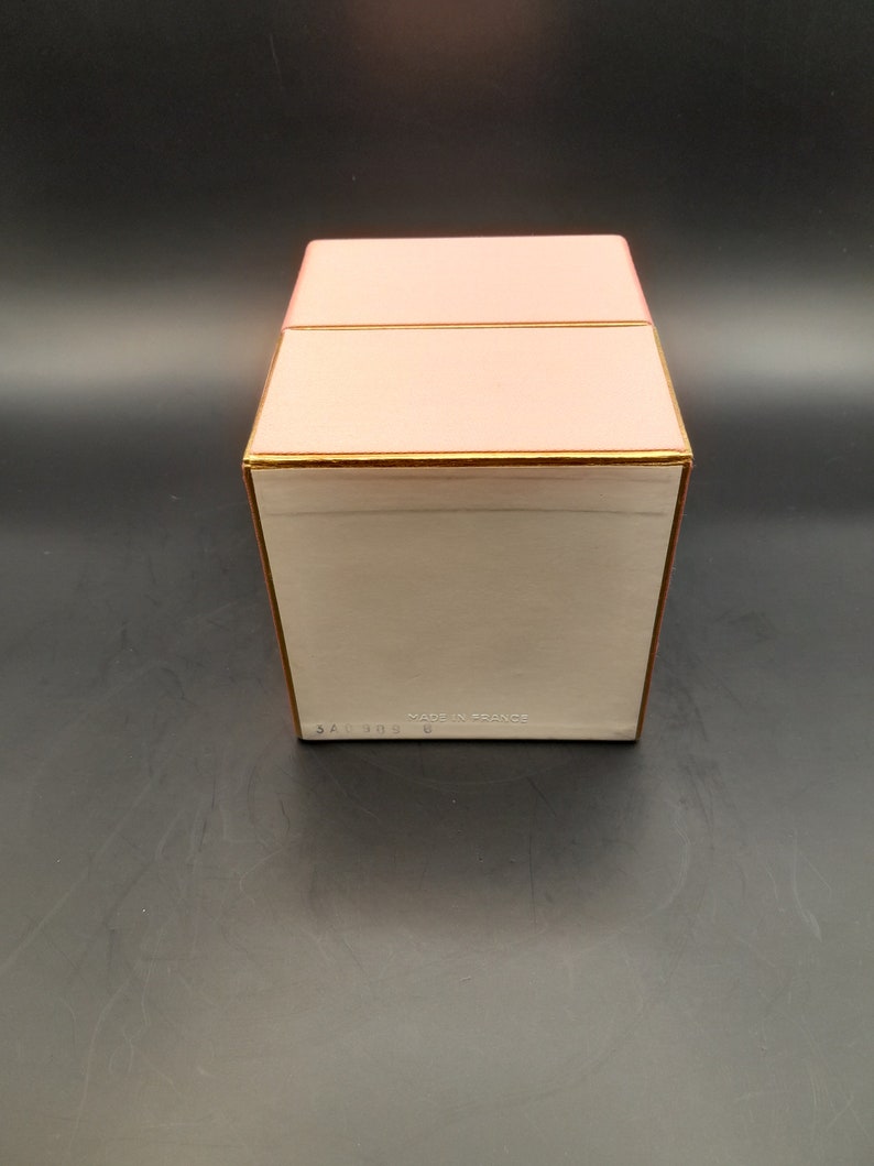 May include: A pink box with a gold trim and the text "MADE IN FRANCE" on the bottom.