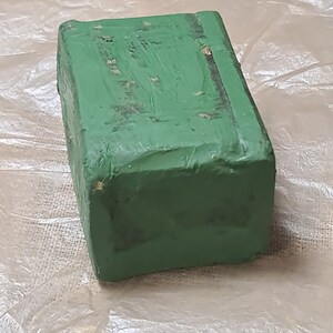 May include: A green rectangular block of floral foam, used for arranging flowers.