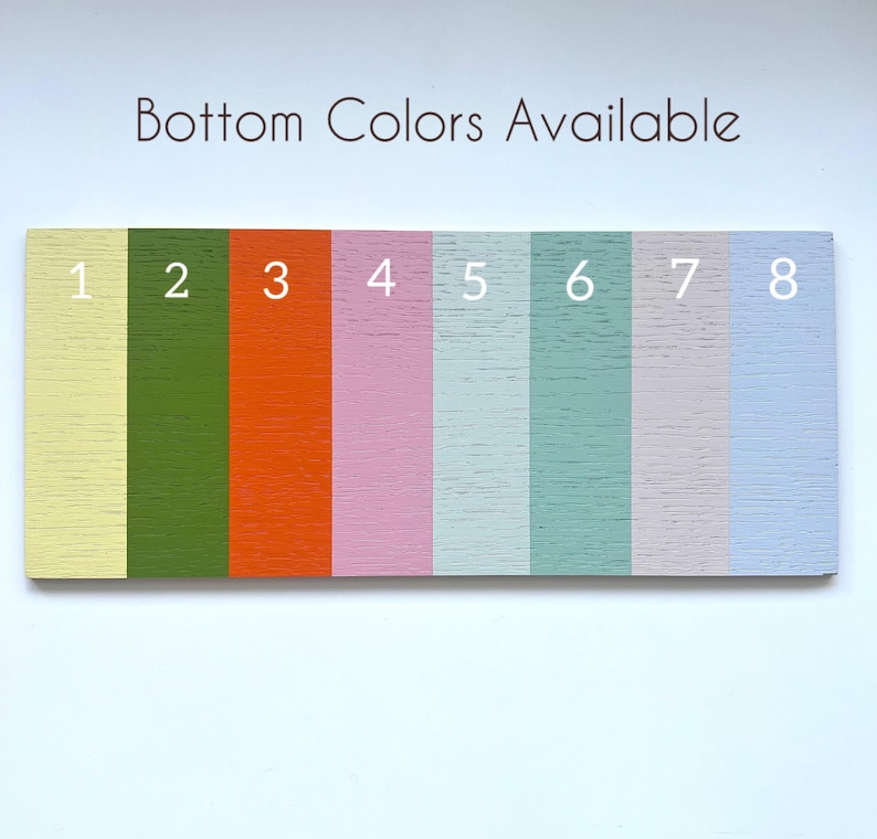 May include: A rectangular wooden sign with eight vertical stripes in various colors: yellow, green, orange, pink, light blue, and gray. The text "Bottom Colors Available" is at the top, with numbers 1-8 next to each color.