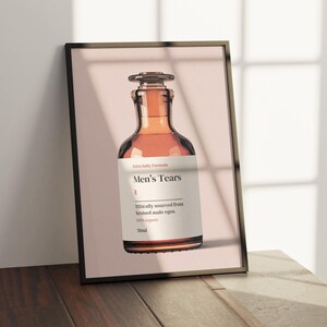 Puede incluir: Una botella de vidrio marr&oacute;n con una etiqueta que dice "Extra Salty Formula Men's Tears Ethically sourced from bruised male egos. 100% organic 30ml".