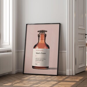 Puede incluir: Un p&oacute;ster con un fondo rosa que presenta una botella de vidrio marr&oacute;n con una etiqueta que dice "Extra Baby Formula Men's Tears Ethically sourced from bruised male egos. 100% organic 30ml"