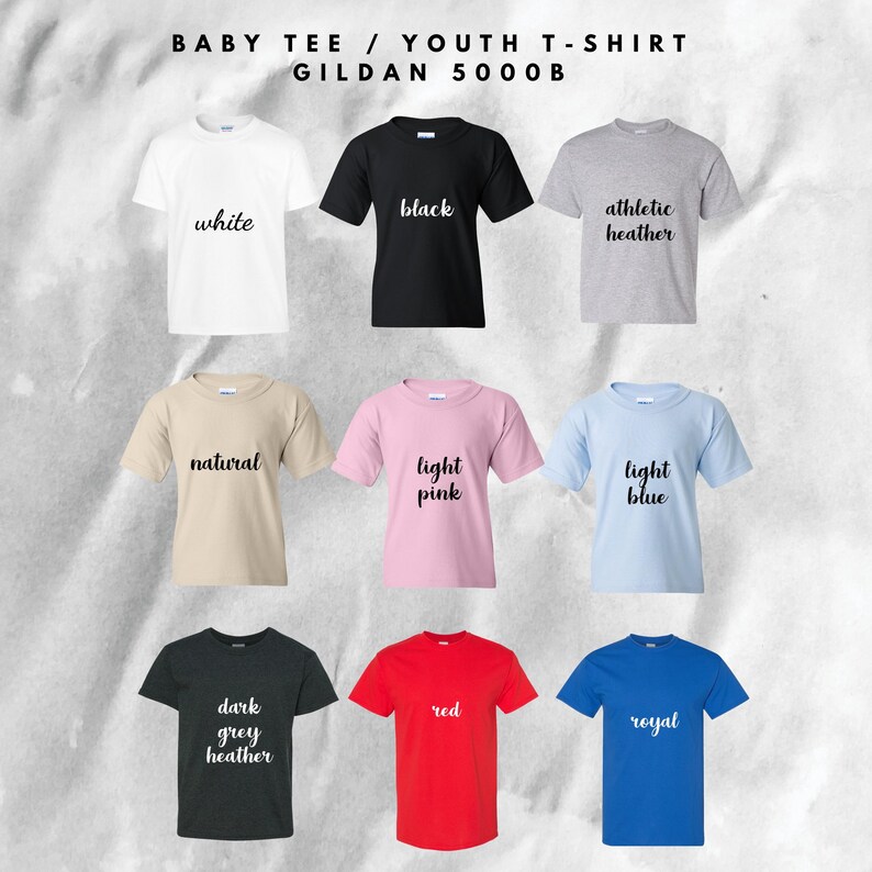 May include: A collection of nine Gildan 5000B baby and youth t-shirts in various colors. Colors include white, black, athletic heather, natural, light pink, light blue, dark grey heather, red, and royal blue. Each shirt has a crew neck.