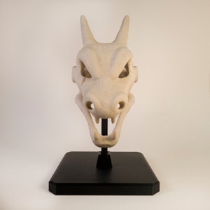 Figurine Crane de Dracaufeu (Pokémon) réaliste. Couleur os et monté sur socle et tige noir. Impression 3D