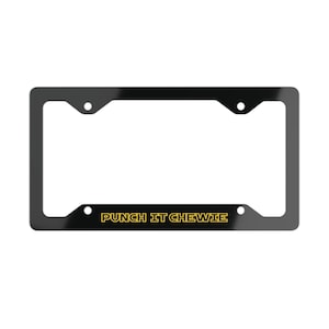 May include: A rectangular black license plate frame with four mounting holes. The bottom horizontal bar features the text PUNCH IT CHEWIE printed in a bold, yellow, outlined sans-serif font centered across the lower section of the frame.