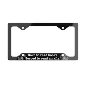 May include: A black rectangular license plate frame featuring white text that reads Born to read books, forced to read emails. The design includes a small graphic of a stack of books on both the left and right sides of the bottom border.