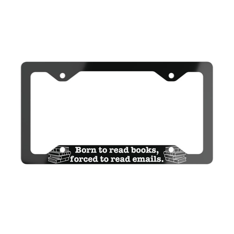 May include: A black rectangular license plate frame featuring white text that reads Born to read books, forced to read emails. The design includes a small graphic of a stack of books on both the left and right sides of the bottom border.