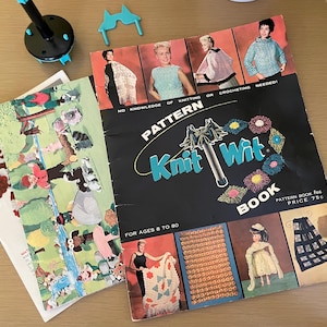 May include: A collection of vintage knitting pattern books, including a "Knit Wit" book with the text "No knowledge of knitting or crocheting needed!" and "For ages 8 to 80." The cover features images of knitted garments. Other books show illustrations of characters and scenes.