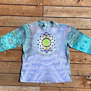 May include: A long-sleeve tie-dye shirt featuring a light purple base with a large, intricate, multi-colored mandala design in the center and smaller matching mandala patterns on each sleeve, showcasing shades of blue, green, and white.