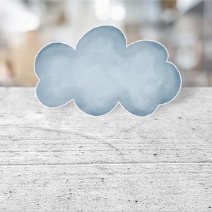 May include: A light blue watercolor cloud shape on a white wood background.