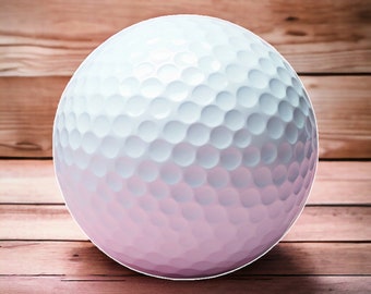 May include: A spherical golf ball featuring a smooth gradient transition from a bright white top to a soft pastel pink bottom. The surface is covered in a uniform pattern of small, circular dimples that create a textured appearance across the ball.