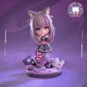 Op de afbeelding: Gedetailleerd beeldje van een personage met kattenoren, gekleed in een donkergrijze en roze outfit. Het beeldje staat op een ronde basis met kussens en een wit kussenvormig kussen. De tekst "Vtubber / FallenShadow" staat op de zijkant.