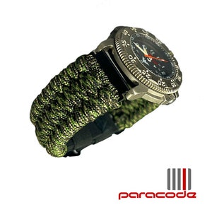 Puede incluir: Una correa de reloj de paracord verde y negro con una esfera de reloj plateada. La esfera del reloj tiene números negros y una aguja de segundos roja.