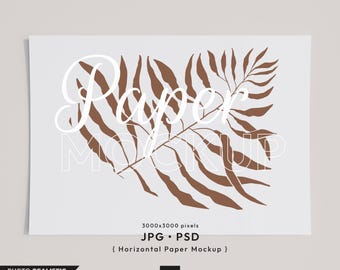 Op de afbeelding: Een witte papiermockup met een bruin bladontwerp en de tekst "Paper Mockup" in wit. De tekst "3000x3000 pixels JPG - PSD (Horizontale papiermockup)" is ook inbegrepen.