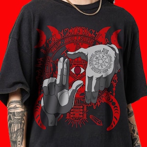 May include: Dark gray t-shirt featuring a red graphic design with the text "HELLSING" and stylized hands framing a red eye. The design includes a pentagram and other symbols.