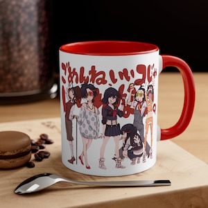 May include: White ceramic mug with a red rim and handle. The mug features a colorful illustration of anime characters with the Japanese text "がんばれ!" printed on the front.