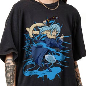 May include: Black t-shirt featuring a blue-haired anime character with a sword, surrounded by blue energy effects. The Japanese text "Hope's Star" is printed vertically on the left side of the graphic.
