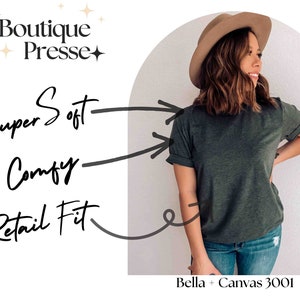 Pu&ograve; includere: Una donna indossa una maglietta verde scuro con il testo "Bella + Canvas 3001" in basso. La maglietta &egrave; descritta come "Super Soft", "Comfy" e "Retail Fit".