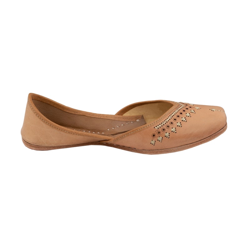 May include: A pair of tan leather shoes with intricate cutouts and gold accents. The shoes have a pointed toe and a low heel.