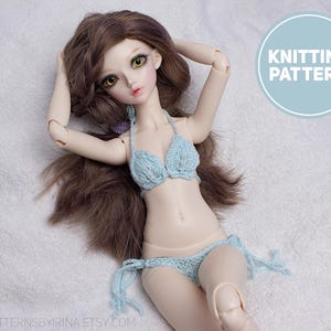Puede incluir: Una muñeca con un bikini de punto azul claro. La muñeca tiene el pelo castaño largo y está tumbada sobre una superficie blanca. La imagen incluye el texto "KNITTING PATTERN" en un círculo azul claro.