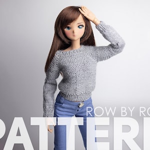 May include: A gray knitted sweater with a round neckline and long sleeves. The sweater is being worn by a doll with long brown hair and blue eyes. The doll is wearing blue jeans.