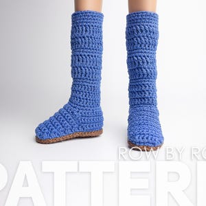 May include: A pair of blue crocheted knee-high socks with a brown sole. The socks are made with a textured stitch pattern. The text "ROW BY ROW PATTERN" is visible at the bottom of the image.