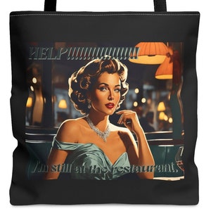 Puede incluir: Una bolsa de tela negra y blanca con una ilustración de estilo vintage de una mujer en un restaurante. El texto "HELP!!!!!!!!!!!" está por encima de la imagen y el texto "I'm still at the restaurant." está por debajo de la imagen.