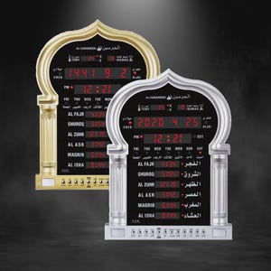Könnte beinhalten: Zwei Digitaluhren mit gewölbtem Oberteil und gold- und silberfarbenem Finish. Die Uhren zeigen Uhrzeit, Datum und Temperatur an. Der Text auf der Uhr ist auf Arabisch und Englisch.