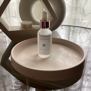 Peut inclure: Une bouteille en verre transparente avec un bouchon et un compte-gouttes en or rose. La bouteille contient une huile de diffusion étiquetée "Unioocandle Huile de diffusion Cashmere & Soie 30 ml".