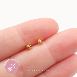 May include: A pair of gold-toned starburst stud earrings with pointed rays. The earrings feature a post-style back and are displayed against a plain background. The text "Stud/Post Earring" and "OLIVE & SKYE" is visible in the lower section.