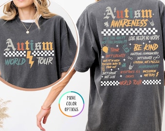 May include: A gray t-shirt with a vintage-style design featuring the text "Autism Awareness World Tour" and a lightning bolt. The back of the shirt has a list of phrases related to autism awareness, including "Think Differently", "Love Needs No Words", and "Be Kind".