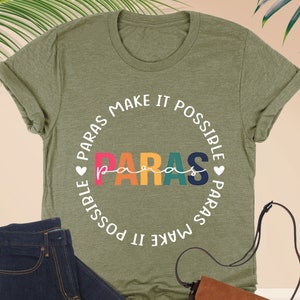May include: Green t-shirt with a white circle design that says "PARAS MAKE IT POSSIBLE PARAS MAKE IT POSSIBLE" with the word "paras" in rainbow colors.