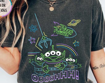 May include: A dark grey t-shirt with a neon graphic of the Pizza Planet aliens. The design includes the Pizza Planet logo, a rocket, and the word "OOOOHHH!". The shirt has a vintage wash and a crew neck.