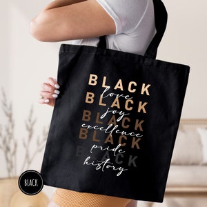a woman carrying a black tote bag
