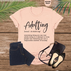 a t - shirt that says,'adulting'and a pair of jeans