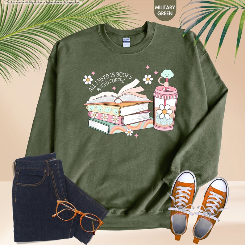 a green sweatshirt with a stack of books next to a pair of sunglasses